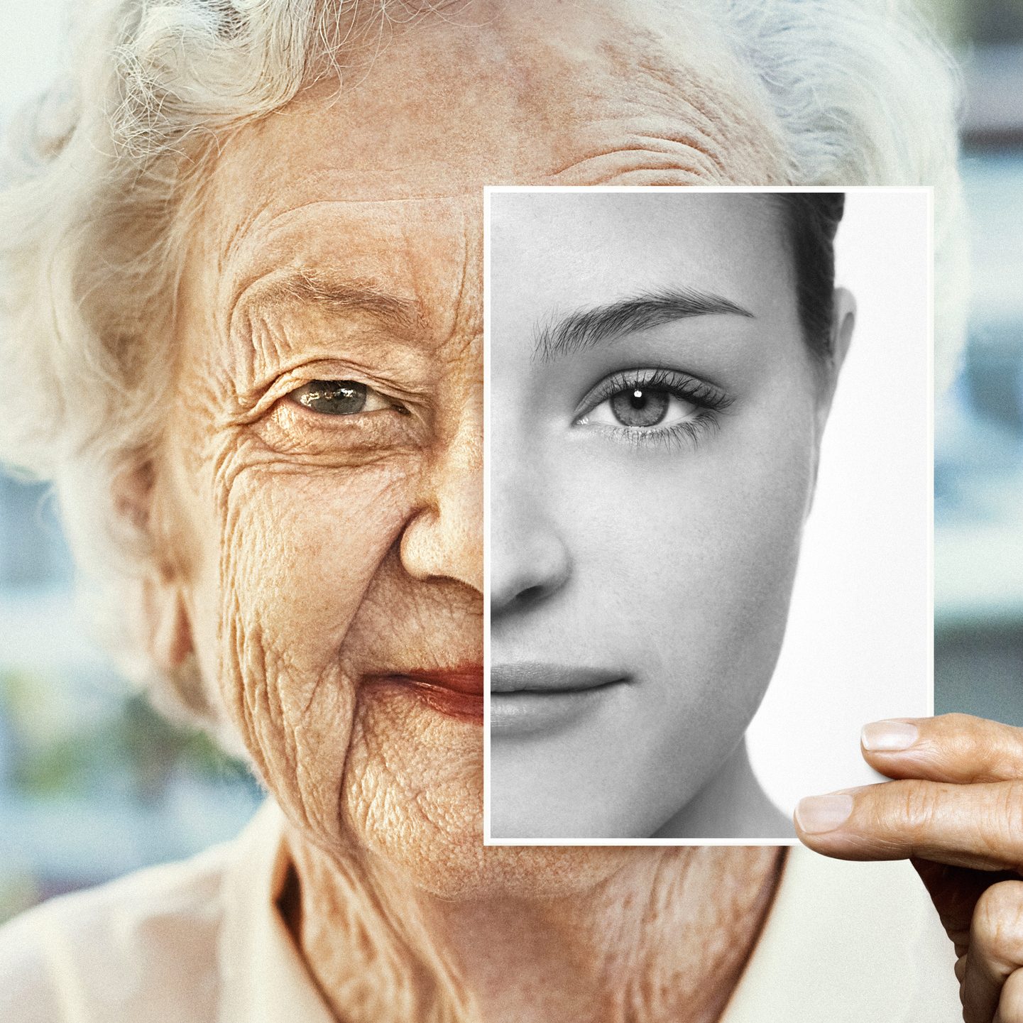 Portrait of woman holding black and white younger photo of herself Portrait of woman holding black and white younger photo of herself